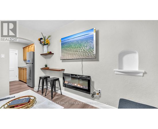 A living room with a flat screen TV mounted on the wall.