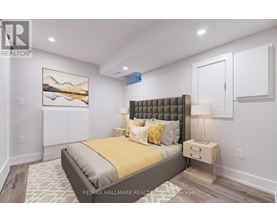 A bedroom with a large bed and a painting on the wall.