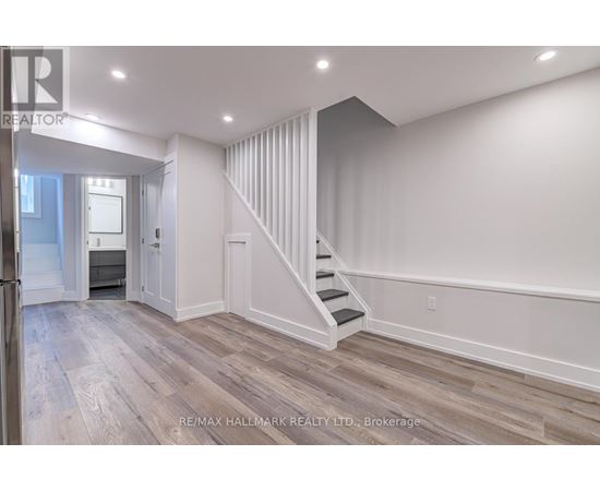 A spacious room with a staircase leading to the upper level.