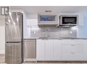 A modern kitchen with a stainless steel refrigerator and white cabinets.