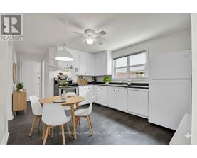 A modern kitchen with white cabinets and a dining table with chairs.