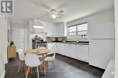 A modern kitchen with white cabinets and a dining table with chairs.