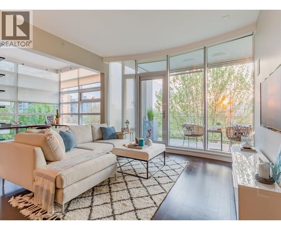 A living room with a white couch and a rug.