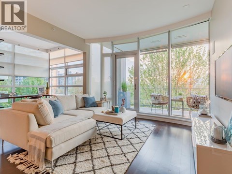 A living room with a white couch and a rug.