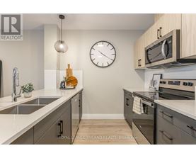 A kitchen with a sink, stove, and oven.