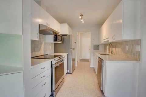 A kitchen with white cabinets and appliances.