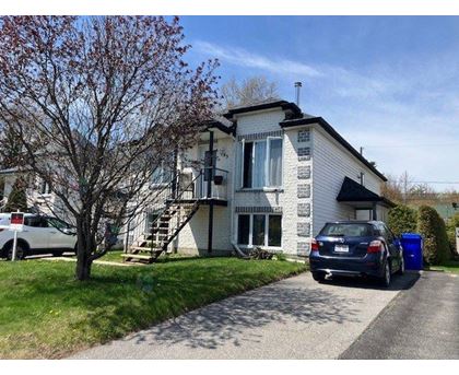 A two-story house with a car parked in front.