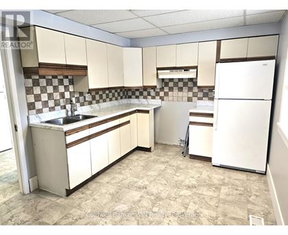 A kitchen with white cabinets and a checkered backsplash.