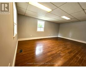 A room with wooden flooring and a window.