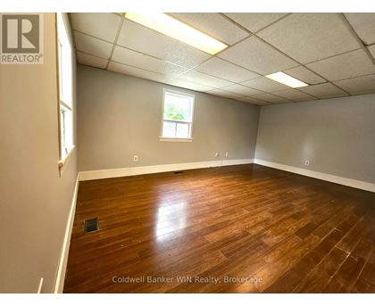 A room with wooden flooring and a window.