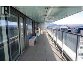 A balcony with a bench and a view of the city.