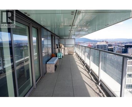 A balcony with a bench and a view of the city.
