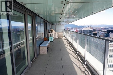 A balcony with a bench and a view of the city.