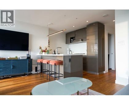 A modern kitchen with a glass table and bar stools.