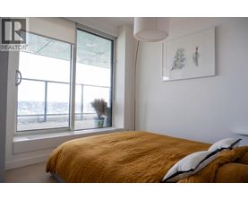 A bedroom with a large bed and a window overlooking a snowy landscape.