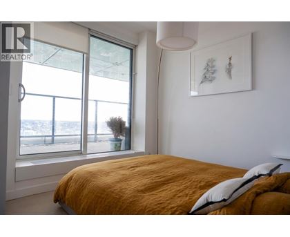 A bedroom with a large bed and a window overlooking a snowy landscape.