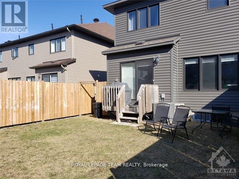 A backyard with a wooden fence and patio furniture.