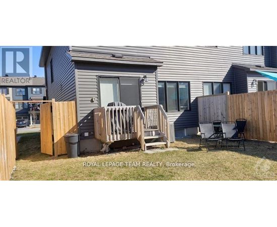 A small house with a deck and a fence.