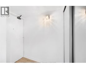 A room with a white wall and a door on the left side.