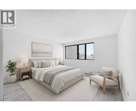 A bedroom with a large bed and a chair.