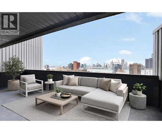 A living room with a couch, chair, and coffee table with a city view in the background.