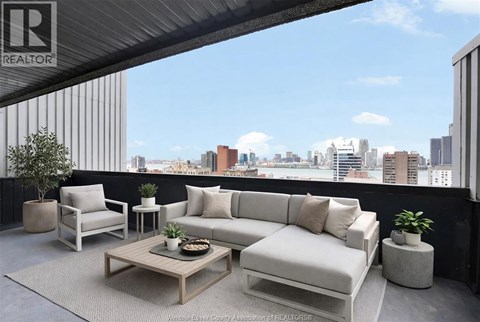 A living room with a couch, chair, and coffee table with a city view in the background.