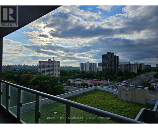 A view from a balcony overlooking a cityscape with a green space in the foreground.