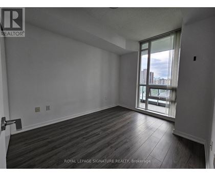A room with wooden flooring and a sliding glass door leading to a balcony.