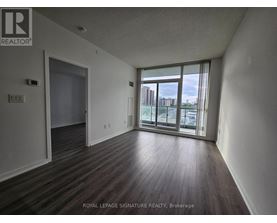 A room with wooden flooring and a sliding glass door leading to a balcony.