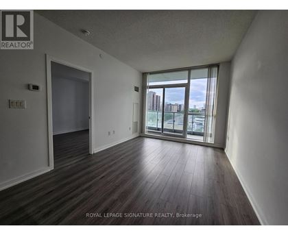 A room with wooden flooring and a sliding glass door leading to a balcony.
