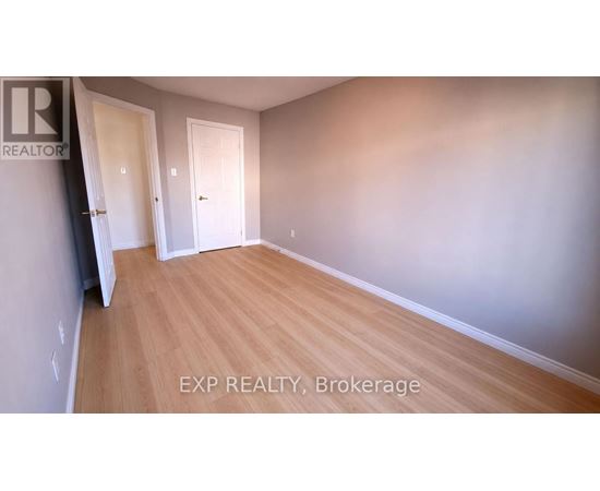 A room with wooden flooring and two white doors.