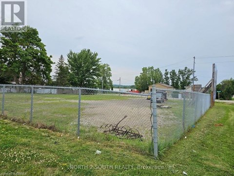 A chain link fence surrounds a vacant lot.