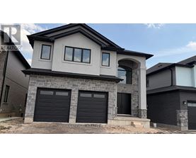 A modern house with a stone facade and black garage doors.