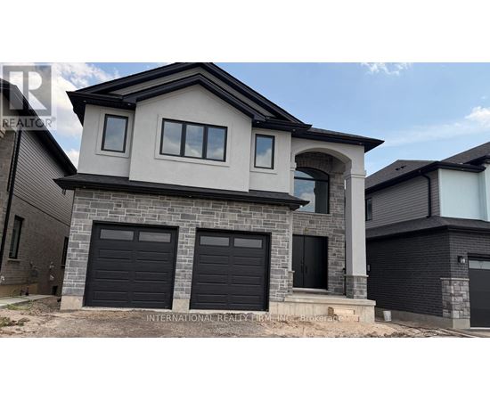 A modern house with a stone facade and black garage doors.