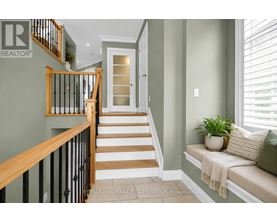A hallway with a staircase and a bench.