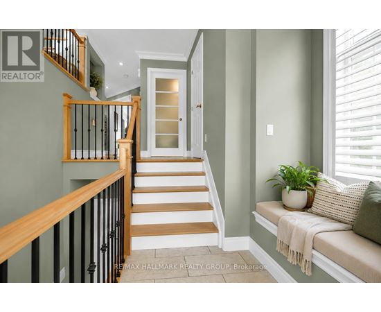 A hallway with a staircase and a bench.