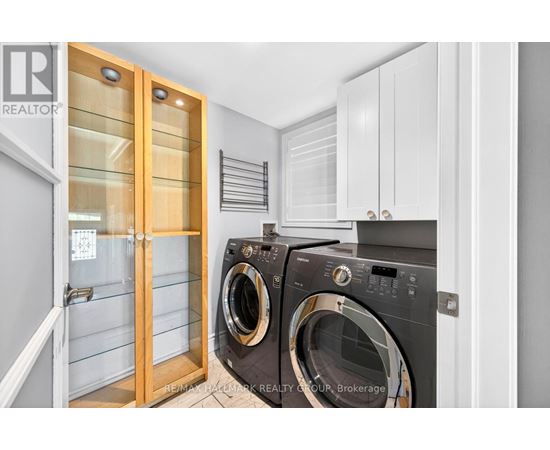 A washing machine in a laundry room with a door open.