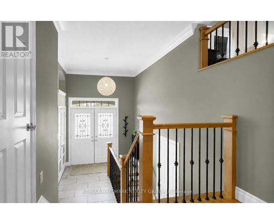A hallway with a white door and a staircase with a wooden banister.