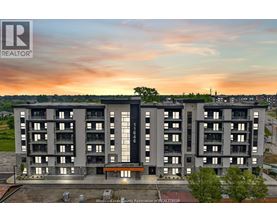 A large apartment complex with a sunset in the background.