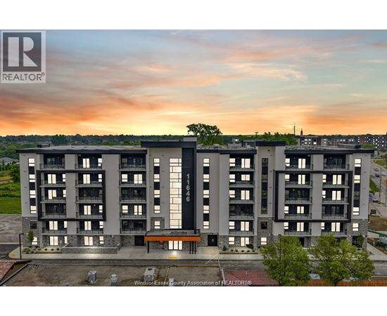 A large apartment complex with a sunset in the background.