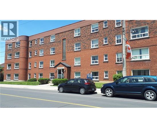 Two cars parked in front of a red brick building.