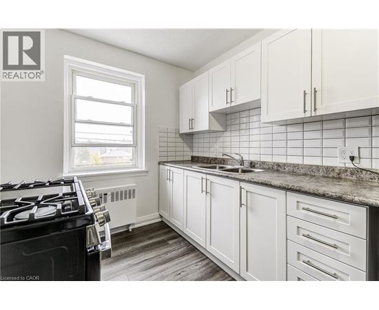 A kitchen with white cabinets and a black stove top.