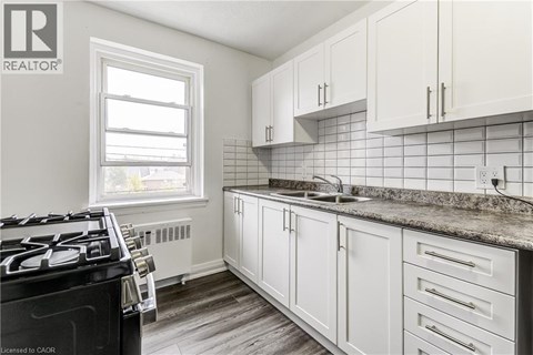 A kitchen with white cabinets and a black stove top.