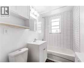 A white bathroom with a toilet, sink, and bathtub.