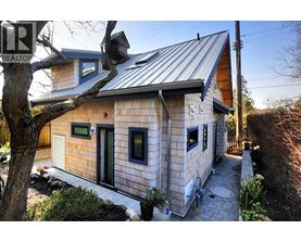 A house with a metal roof and a stone exterior is shown.