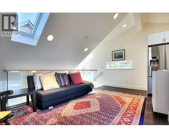 A living room with a couch and a rug.