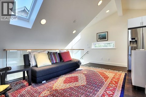 A living room with a couch and a rug.