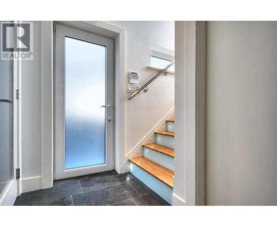 A staircase with a glass door leading to a balcony.