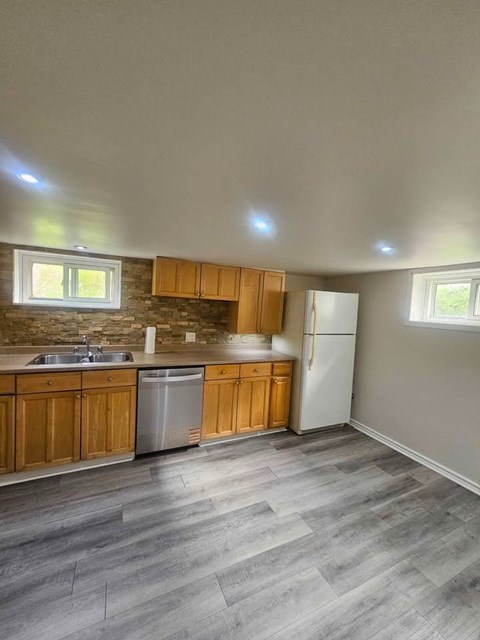 A kitchen with wooden cabinets and a white refrigerator.