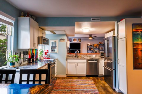 A kitchen with a blue table and white cabinets.